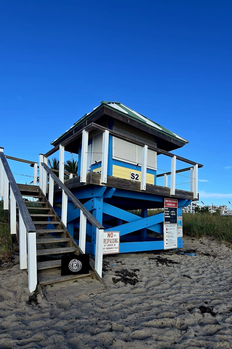 Blue lifeguard tower on a sandy beach with clear blue sky
